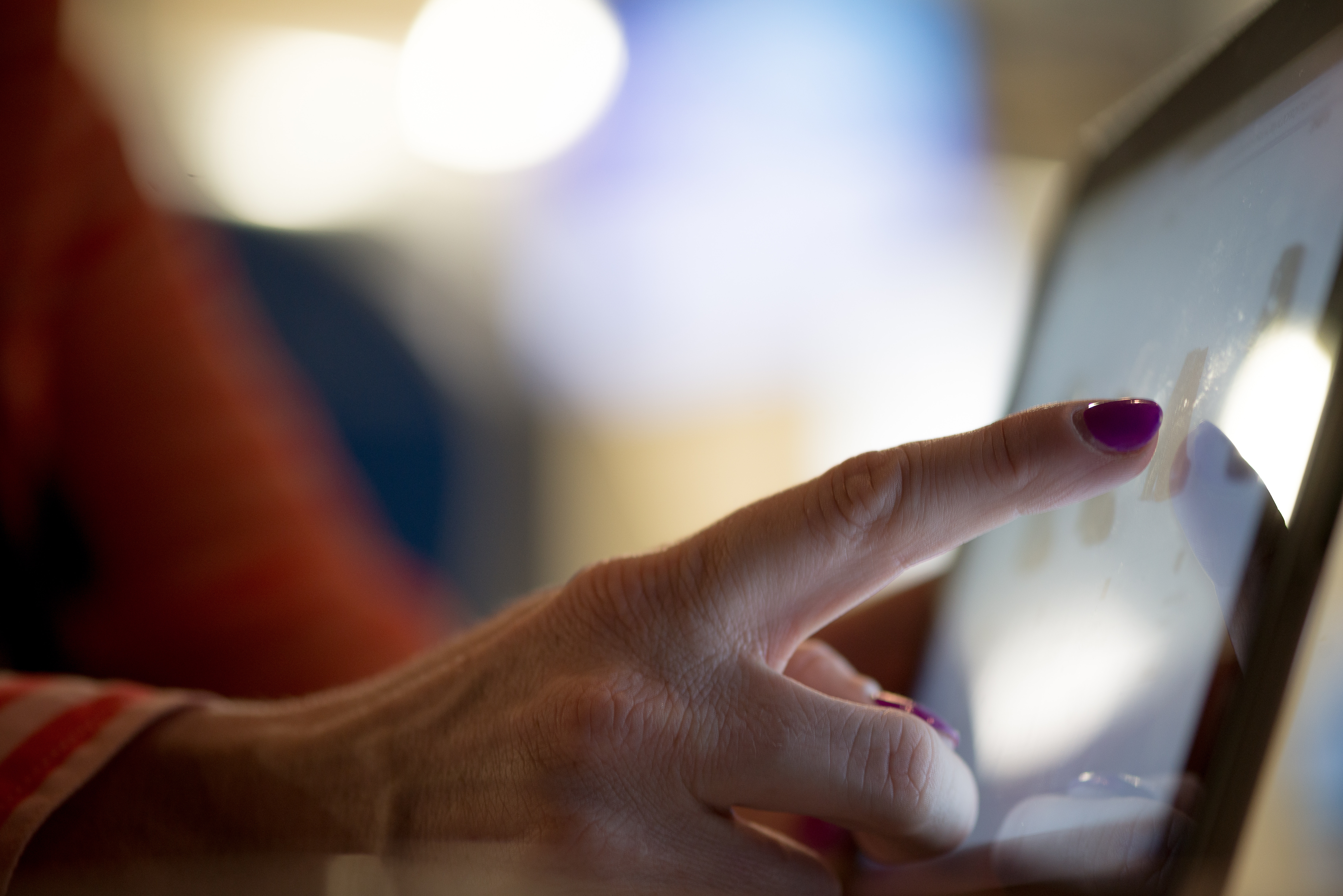 Woman touching a screen on a payment kiosk.