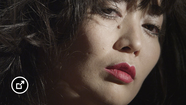 Beauty shot of person with dark hair and red lipstick