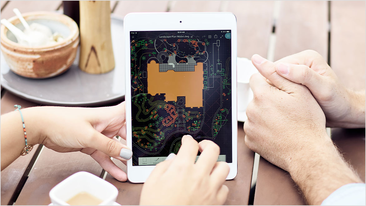 Two people viewing AutoCAD drawing on mobile tablet 