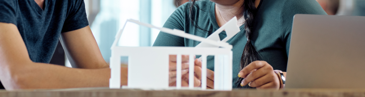 Man and woman discussing architectural model on table